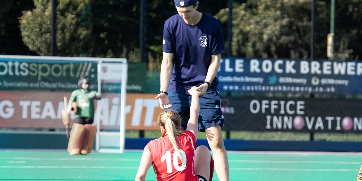 Player being helped off the ground at the England Hockey Championships 