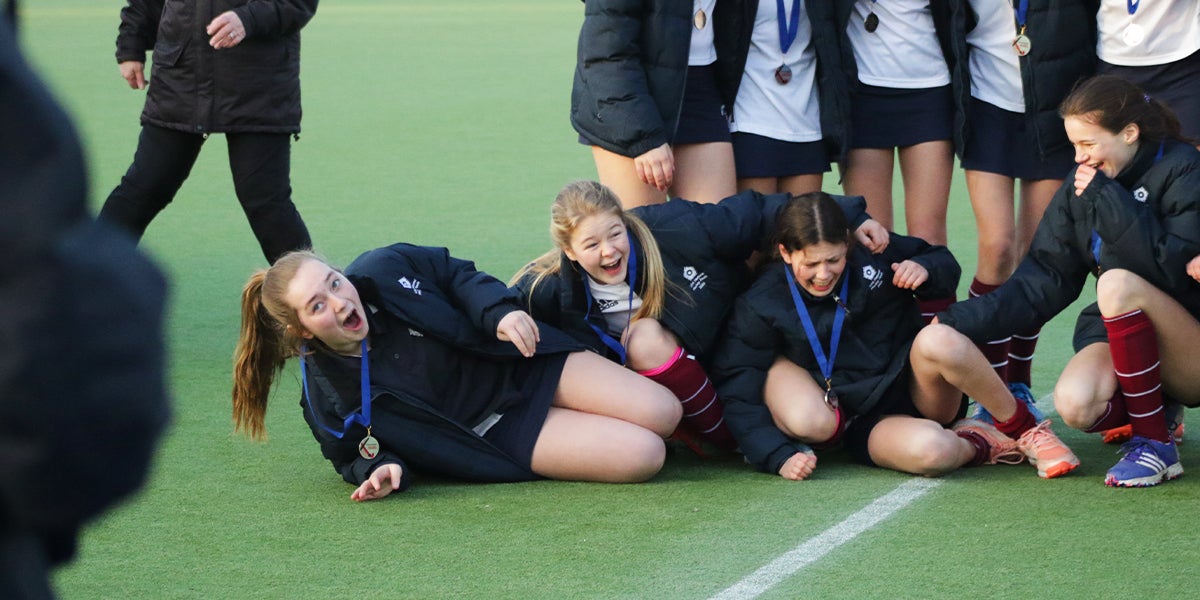 Girls smiling and laughing at presentation of awards for the Girls Schools Games 