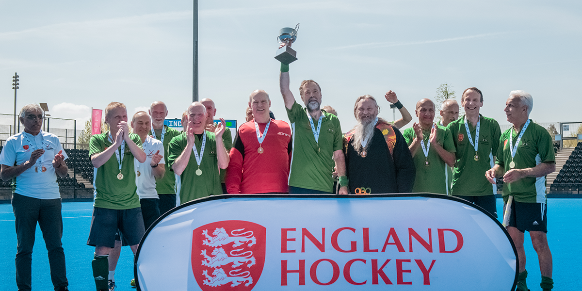 Mens masters team celebrating with trophy